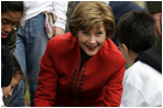 Mrs. Laura Bush helps children plant flowers at the First Bloom Event, Monday, April 21, 2008, during her visit to celebrate National Park week at the Castle Clinton National Monument in New York City.