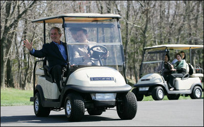 President George W. Bush waves as South Korean President Lee Myung-bak drives their golf cart, followed by Laura Bush and South Korea first lady Kim Yoon-ok in theirs Friday, April 18, 2008, at the Presidential retreat at Camp David, Md.