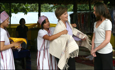 Mrs. Laura Bush and daughter Ms. Barbara Bush examine local wares after a dance ceremony and viewing traditional Karen weaving at the Mae La Refugee Camp at Mae Sot, Thailand, on Aug. 7, 2008. Mrs. Bush's visit to one of the largest refugee camps on the border was at the top of a mountain on the border with Burma. In her comments, Mrs. Bush noted the generosity of the Thai government and the people of Thailand in allowing the nine camps to exist there.