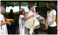 Mrs. Laura Bush and daughter Ms. Barbara Bush examine local wares after a dance ceremony and viewing traditional Karen weaving at the Mae La Refugee Camp at Mae Sot, Thailand, on Aug. 7, 2008. Mrs. Bush's visit to one of the largest refugee camps on the border was at the top of a mountain on the border with Burma. In her comments, Mrs. Bush noted the generosity of the Thai government and the people of Thailand in allowing the nine camps to exist there.