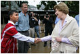 Mrs. Laura Bush is greeted as she prepares to enter a school at the Mae La Refugee Camp in Mae Sot, Thailand, where an English grammar class is being taught. Her Aug. 7, 2008 visit to the camp which houses at least 39,000 Burmese refugees, highlighted the plight of a people who have struggled since the Aug. 8, 1988 crackdown that created dire conditions in their country 20 years ago. Many have moved on to the United States or other countries such as Canada, New Zealand or the Netherlands. Mrs. Bush encouraged other countries to help the Burmese as well.