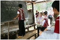 Mrs. Laura Bush watches as an English student works at the chalkboard of a grammar class at the Mae La Refugee Camp in Mae Sot, Thailand, on Aug. 7, 2008. The English lesson on the chalkboard uses the sentence to discuss compound sentence structure: "My life in refugee is better than Burma but I don't have opportunity to go outside of my camp. The visit to the camp in Mae Sot, Thailand, highlighted the fact that it has been 20 years since the crackdown in Burma that sent many people fleeing the dire conditions. Many residents have been born in one of the nine camps along the border or have lived most of their lives there.