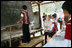 Mrs. Laura Bush watches as an English student works at the chalkboard of a grammar class at the Mae La Refugee Camp in Mae Sot, Thailand, on Aug. 7, 2008. The English lesson on the chalkboard uses the sentence to discuss compound sentence structure: "My life in refugee is better than Burma but I don't have opportunity to go outside of my camp. The visit to the camp in Mae Sot, Thailand, highlighted the fact that it has been 20 years since the crackdown in Burma that sent many people fleeing the dire conditions. Many residents have been born in one of the nine camps along the border or have lived most of their lives there.