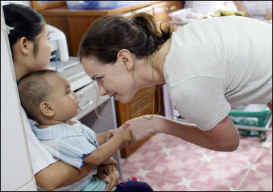 Ms. Barbara Bush, daughter of President George W. Bush and Mrs. Laura Bush, spends a playful moment with a small child during her visit to the Mae Tao Clinic at the Mae La Refugee Camp in Mae Sot, Thailand Thursday, Aug. 7, 2008. 