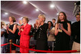 Mrs. Laura Bush stands with Mrs. Sarah Randt, spouse of U.S. Ambassador to China Sandy Randt, left, Mrs. Anne Johnson, Director of Art in Embassies Program, and Ms. Barbara Bush during applause for President George W. Bush Friday, Aug. 8, 2008, at the dedication ceremony for the U.S. Embassy in Beijing.