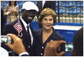 Mrs. Laura Bush with U.S. Flag Bearer Lopez Lomong as she greets members of the U.S. Summer Olympic Team at the Fencing Hall in Beijing on August 8, 2008. Mr. Lomong is a survivor of the violence in his native Sudan. He is now a U.S. citizen and was selected by his teammates to lead the U.S. Olympic team into the Olympic National Stadium carrying the United States Flag at the Opening Ceremony, which followed shortly after this picture was taken. 