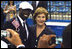 Mrs. Laura Bush with U.S. Flag Bearer Lopez Lomong as she greets members of the U.S. Summer Olympic Team at the Fencing Hall in Beijing on August 8, 2008. Mr. Lomong is a survivor of the violence in his native Sudan. He is now a U.S. citizen and was selected by his teammates to lead the U.S. Olympic team into the Olympic National Stadium carrying the United States Flag at the Opening Ceremony, which followed shortly after this picture was taken. 