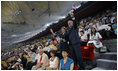 President George W. Bush waves an American flag as he and Mrs. Laura Bush stand and cheer during the entrance of the U.S. athletes into China's National Stadium Friday, Aug. 8, 2008, in Beijing.