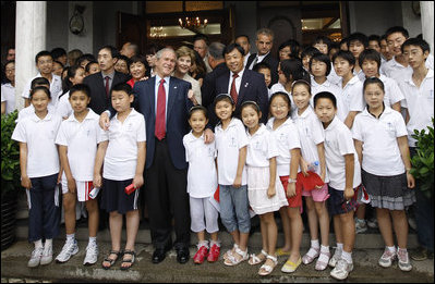 President George W. Bush and Mrs. Laura Bush stand outside the Kuanjie Protestant Christian Church with members of the Kuanjie Summer Vacation School Choir after attending services Sunday, Aug. 10, 2008, in Beijing.