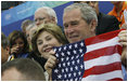 President George W. Bush and Mrs. Laura Bush cheer on the U.S. Olympic swimmers during the Sunday morning competition at the National Aquatics Center in Beijing.