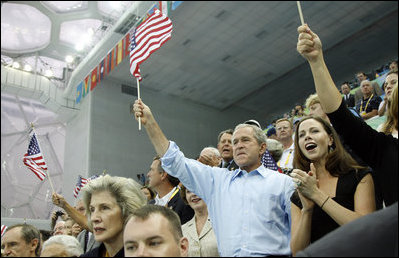 President George W. Bush, Mrs. Laura Bush and daughter Barbara Bush join the fans at the National Aquatics Center as they cheer on U.S. swimmer Michael Phelps as he swam his world-record setting 400-Meter Individual Medley event Sunday, Aug. 10, 2008, in Beijing.