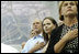 President George W. Bush, daughter Barbara Bush and Mrs. Doro Koch, the President's sister, stand for the playing of the U.S. national anthem Sunday, Aug. 10, 2008, during the medal ceremony honoring gold medalist Michael Phelps. The U.S. Olympian won his first event, the 400-meter Individual Medley, in a record time of 4:3.84.