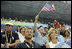 President George W. Bush, accompanied by Mrs. Laura Bush, waves an American flag as he cheers for the U.S. Olympic swimming team Monday, Aug. 11, 2008, in the National Aquatic Center at the 2008 Summer Olympic Games in Beijing.