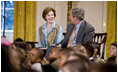 Mrs. Laura Bush and President George W. Bush sit with youngsters Monday, Dec. 8, 2008, during the Children's Holiday Reception and Performance in the East Room of the White House.