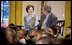 Mrs. Laura Bush and President George W. Bush sit with youngsters Monday, Dec. 8, 2008, during the Children's Holiday Reception and Performance in the East Room of the White House.