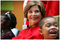 Mrs. Laura Bush watches Barney Cam VII: A Red, White & Blue Christmas as it debuts for children at Children's National Medical Center in Washington, D.C. on Dec. 15, 2008. With Mrs. Bush are her two patient escort volunteers, Dania Jecty, left, age 11, and Elmer Reyes, age 13. Visiting the hospital is an annual tradition for Mrs. Bush, and one she says she will miss.