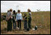 Mrs. Laura Bush joins Florida City Elementary School students Cornesha Dericho, left, and Dania Amaya, along with park ranger Allyson Gantt, right, as they prepare to plant a Gumbo Limbo tree Wednesday, Feb. 6, 2008, during the Junior Ranger "First Bloom" planting event in Everglades National Park, Fla. Mrs. Bush praised the Everglades restoration program which hopes to plant native trees to replace invasive species that are choking the park.