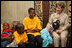 A young girl rests her head on Mrs. Laura Bush’s lap Sunday, Feb. 17, 2008, as she visits with orphans and caretakers in the Living Room of the WAMA Foundation, a non-profit organization founded by Salma Kikwete, First Lady of Tanzania.