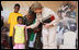 Mrs. Laura Bush pats the back of 7-year-old Zuwena Dooto, after she presented Mrs. Bush with a scrapbook during the launch of the National Plan for Action event at the WAMA Foundation Sunday, Feb. 17, 2008, in Dar es Salaam.