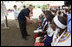 President George W. Bush, joined by Mrs. Laura Bush, greets guests, students and their families during a welcome program Monday, Feb. 18, 2008, to the Maasai Girls School in Arusha, Tanzania.