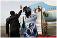 Tanzanian President Jakaya Kikwete and first lady Salma Kikwete, wearing a blouse imprinted with a likeness of President George W. Bush, wave farewell to President Bush and Mrs. Laura Bush Tuesday, Feb. 19, 2008 at Julius Nyerere International Airport in Dar es Salaam, Tanzania.