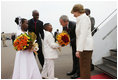 President George W. Bush and Mrs. Laura Bush are greeted by children with flowers on their arrival Tuesday, Feb. 19, 2008 to Kigali International Airport in Kigali, Rwanda.