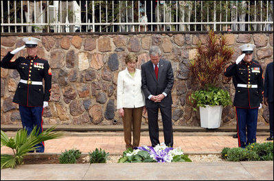 Flanked by saluting U.S. Marines President George W. Bush and Mrs. Laura Bush pause for a moment of silence after laying a wreath on a mass grave at the genocide memorial Tuesday, Feb. 19, 2008, at the Kigali Memorial Centre in Kigali, Rwanda.