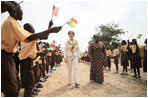 Mrs. Laura Bush and Ghana first lady Mrs. Theresa Kufuor, are greeted by singing students waving flags, on their arrival to Mallam D/A Primary School, Wednesday, Feb. 20, 2008 in Accra, Ghana.