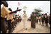 Mrs. Laura Bush and Ghana first lady Mrs. Theresa Kufuor, are greeted by singing students waving flags, on their arrival to Mallam D/A Primary School, Wednesday, Feb. 20, 2008 in Accra, Ghana.