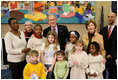 President George W. Bush and Laura Bush are joined by Washington, D.C. Mayor Adrian Fenty, right, and Ginnie Cooper,Chief Librarian for the Washington, D.C. libraries, left, posing for photos with children and staff at a reading class commemorating Martin Luther King Day Monday, Jan. 21, 2008, at the Martin Luther King Jr. Memorial Library.