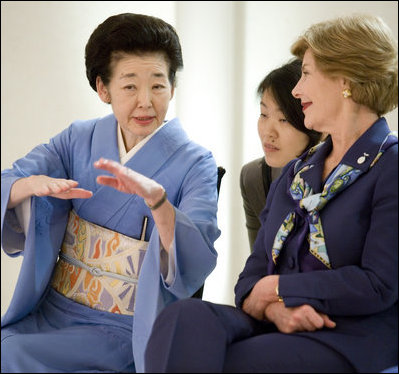 As Mrs. Laura Bush listens, Mrs. Kiyoko Fukuda, spouse of Prime Minister Yasuo Fukuda of Japan, explains the finer details on proper dressing techniques during a demonstration for G-8 spouses of a Junihitoe 12-layered Ancient Kimono Monday, July 7, 2008, at the Windsor Hotel Toya Resort and Spa in Toyako, Japan.