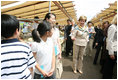 Mrs. Laura Bush waves at children as she walks the aisles of the Hokkaido Marche, a farmer's market in Makkari Village, on Hoikkaido, Japan, Tuesday, July 8, 2008, during a G-8 Spouses Program. Makkari, a village of 2,323 people, is known especially for its lilies and its potatoes.