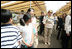 Mrs. Laura Bush waves at children as she walks the aisles of the Hokkaido Marche, a farmer's market in Makkari Village, on Hoikkaido, Japan, Tuesday, July 8, 2008, during a G-8 Spouses Program. Makkari, a village of 2,323 people, is known especially for its lilies and its potatoes.