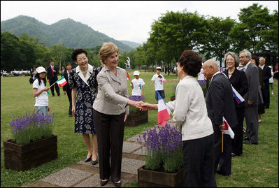 Mrs. Laura Bush, accompanied by Mrs. Kiyoko Fukuda, spouse of the Prime Minister of Japan, left, is greeted as she arrives to the Toyako New Mount Showa Memorial Park for a ceremonial tree planting ceremony with other G-8 spouses Wednesday, July 9, 2008, in Hokkaido, Japan. 