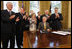 President George W. Bush is applauded after signing H.J. Res. 93, the Renewal of Import Restrictions on Burma and H.R. 3890, the Tom Lantos Block Burmese JADE Act of 2008, Tuesday, July 29, 2008 in the Oval Office of the White House. Applauding President Bush are, from left, Rep. Don Mansullo, R-Ill.; Rep. Chris Smith, R-N.J.; Mrs. Laura Bush, Annette Lantos, widow of Rep. Tom Lantos; Lantos grandson, Shiloh Tilleman; Rep.Rush Holt, D-N.J.; Rep. Joe Pitts, R-Pa.; and Rep. Peter King, R-N.Y.