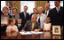 President George W. Bush is joined at his desk by Hannah Lewis, age 7, left, Wyatt Rech, age 6, Eden Adams, age 8, right, Mrs. Laura Bush, other family members, and Sen. Norm Coleman R-MN; Rep. Deborah Pryce R-OH; and Rep. Chris Van Hollen D-MD; Tuesday, July 29, 2008, after signing the Caroline Pryce Walker Conquer Childhood Cancer Act of 2008 in the Oval Office of the White House.