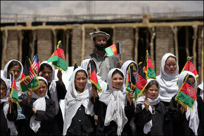 Future students of the Ayenda Learning Center wave flags and greet Mrs. Laura Bush during her visit to the construction site of the Ayenda Learning Center Sunday, June 8, 2008, in Bamiyan, Afghanistan.