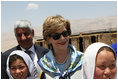 Mrs. Laura Bush is joined by Ihsan Ullah Bayat, top let, and young Afghan girls during a tour of the construction site of the Ayenda Learning Center Sunday, June 8, 2008, in Bamiyan, Afghanistan.