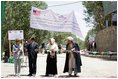 Mrs. Laura Bush, left, assists local officials with the ribbon cutting ceremony June 9, 2008 in Afghanistan at the ground-breaking ceremonies for the 1.96 kilometer Bamiyan road project through the bazaar. The new road will link up with a 1.72 kilometer road from the airport to the town center completed in 2007 with U.S. support.