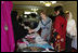 Mrs. Laura Bush greets local businesswomen as she tours the marketplace of the Arzu and Bamiyan Women's Business Association on June 9, 2008 in Afghanistan. The carpets, embroidery and other Afghan wares are all made by women.