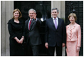 President George W. Bush waves to members of the media as he and Laura Bush are met by British Prime Minster Gordon Brown and his wife, Sarah, on their arrival Sunday, June 15, 2008 to 10 Downing Street in London.