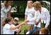 Mrs. Laura Bush takes a closer looks at a flower during a First Bloom planting event at Charlestown Navy Yard Sunday, June 22, 2008 in Boston, MA. Students of the Boys and Girls Club of Boston and Warren Prescott Elementary School participated in a three-day workshop that focused on invasive species, native plants, seed cultivation, garden design, and monitoring species.