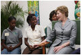 Mrs. Laura Bush speaks with a clinic patient and at risk adolescents during her visit Thursday, March 13, 2007 at the GHESKIO HIV/AIDS Center in Port-au-Prince, Haiti. GHESKIO is a participant in the President's Emergency Plan for AIDS Relief (PEPFAR), which has contributed approximately $365 million to fight HIV/AIDS in Haiti.