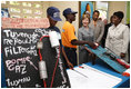 Mrs. Laura Bush, joined by Guerda Previlon, right, chief of party IDEJEN, and Gabriel Bienime, Haiti Education Minister, visits with a student enrolled in the IDEJEN educational program at the College de St. Martin Tours Thursday, March 13, 2008, in Port-au-Prince, Haiti.