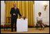 Mrs. Laura Bush looks on as the Westminster Kennel Club's 2008 Best in Show Winner, Uno, and his co-owner Eddie Dziuk address guests during their visit to the White House Monday, May 5, 2008, in the East Room of the White House.