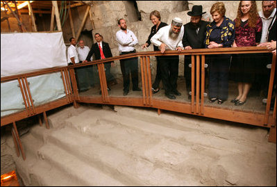 Listening to Mr. Mordechi Eliav as he describes the ongoing construction project that is the Western Wall Tunnels, Mrs. Laura Bush and Mrs. Aliza Olmert, spouse of Israeli Prime Minister Ehud Olmert, participate in a tour of the Jerusalem site.