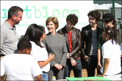 Surrounded by children participating in a soil sampling event, Mrs. Laura Bush speaks with Benjamin Jones, Director of Education, Trinity River Audubon Center, left during the First Bloom event at the Trinity River Audubon Center Sunday, November 2, 2008, in Dallas, TX. Mrs. Bush is joined by singer/songwriters the Jonas Brothers, Kevin Jonas, Joe Jonas, and Nick Jonas, right.