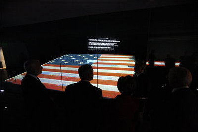 President George W. Bush is silhouetted against the renovated Star-Spangled Banner American flag exhibit Wednesday, Nov. 19, 2008, during his visit with Mrs. Laura Bush to the National Museum of American History in Washington, D.C. The flag, which flew above Fort McHenry in Baltimore during the British attack in 1814, inspired Francis Scott Key to write the lyrics that became our national anthem.