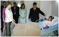 Mrs. Laura Bush spends a moment with Ms. Robalba Robinson, a breast cancer patient recovering from recent reconstructive surgery, during a visit Friday, Nov. 21, 2008, to the National Oncology Institute in Panama City. Joining her is Mrs. Vivian Fernandez de Torrijos, First Lady of Panama, in pink, and Dr. Rosario Turner, Panama's Minister of Health. The man at right is unidentified.