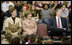 Mrs. Laura Bush enjoys a school assembly program, with Ms. Wilda Lu Nelson, Principal of the Riverside Elementary School, left, and Dr. Thomas Lindsay, Deputy Chairman of the National Endowment for the Humanities, during a visit to the school in Bismarck, N.D., Thursday, Oct. 2, 2008.